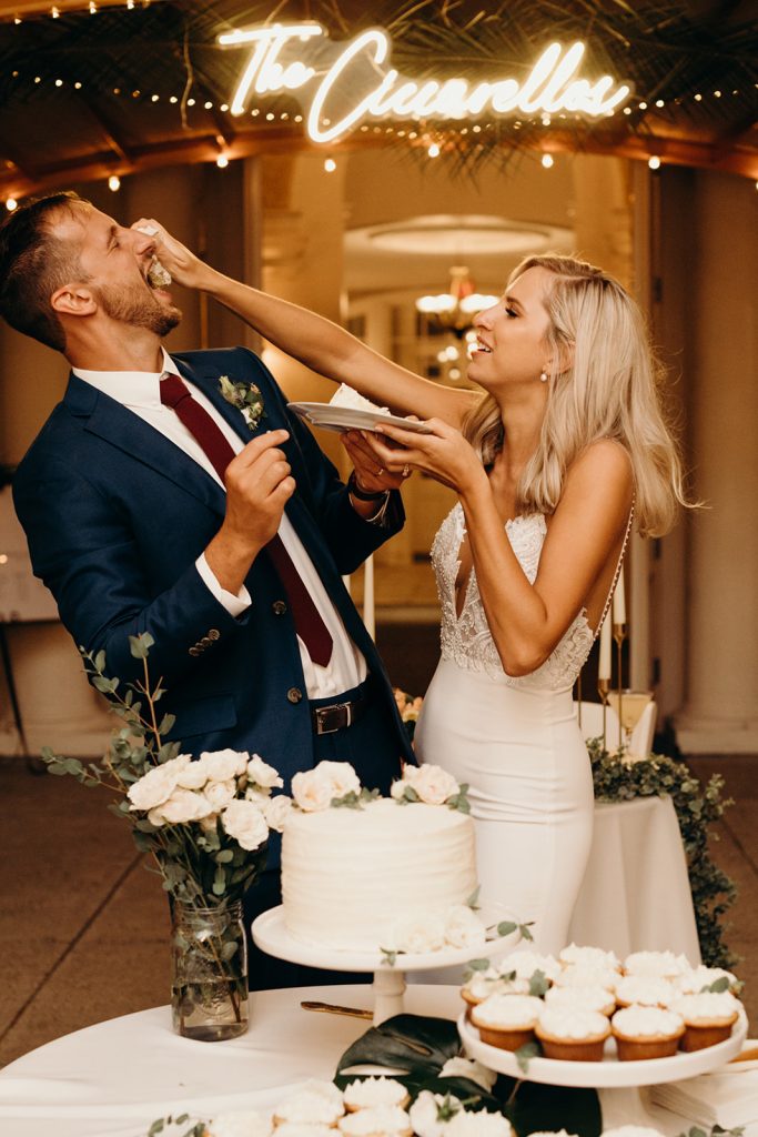 Bride shoves cake into groom's mouth